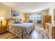 Bedroom with natural light, wood flooring, and a comfortable bed at 1750 Belleair Forest Dr # A7, Belleair, FL 33756