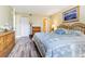 This is a primary bedroom with wood laminate flooring and a door to the attached bathroom at 1750 Belleair Forest Dr # A7, Belleair, FL 33756