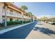 Exterior view of condo community with red tile roofs, palm trees, and assigned parking at 1750 Belleair Forest Dr # A7, Belleair, FL 33756