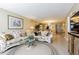 Spacious living room features a comfortable floral sofa, glass coffee table, and tile flooring at 1750 Belleair Forest Dr # A7, Belleair, FL 33756