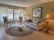 Cozy living room features neutral tones, comfortable seating, and a serene view through large windows at 1750 Belleair Forest Dr # A7, Belleair, FL 33756
