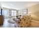 The living room with chairs and a glass top coffee table is decorated with a colorful sofa at 1750 Belleair Forest Dr # A7, Belleair, FL 33756