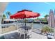 Waterfront deck view with an umbrella, table, chairs, and railing overlooking the tranquil canal at 18675 Us Highway 19 N # 251, Clearwater, FL 33764