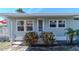 Charming home featuring a cozy porch and manicured landscaping with decorative plants at 18675 Us Highway 19 N # 251, Clearwater, FL 33764