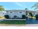 Charming single-story home with manicured landscaping, a covered carport, and tidy lawn at 18675 Us Highway 19 N # 251, Clearwater, FL 33764
