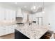 Stylish kitchen featuring white cabinets, a granite island, and stainless steel appliances at 2007 Belleair Rd, Clearwater, FL 33764