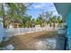 Spacious backyard featuring a white picket fence, lush trees, and green grass at 2011 1St St, Indian Rocks Beach, FL 33785