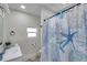 Well-lit bathroom featuring a clean white vanity, a decorative shower curtain, and modern fixtures at 2011 1St St, Indian Rocks Beach, FL 33785