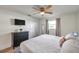 Inviting bedroom features a ceiling fan, window, and a dresser with mounted TV for comfort and convenience at 2011 1St St, Indian Rocks Beach, FL 33785