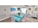 Bright dining area with a coastal-style table, seating, beach-themed art, and a view of the adjacent living space at 2011 1St St, Indian Rocks Beach, FL 33785