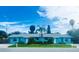 Inviting blue exterior of this charming duplex with a well manicured lawn and lovely tropical landscaping at 2011 1St St, Indian Rocks Beach, FL 33785