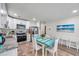 Well-lit kitchen with white cabinets, stainless steel appliances, and a rustic dining table at 2011 1St St, Indian Rocks Beach, FL 33785