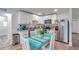 Bright kitchen featuring white cabinets, stainless steel appliances, and a cozy dining area at 2011 1St St, Indian Rocks Beach, FL 33785