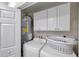 Utility room with a washing machine, dryer, and water heater with a storage cabinet at 2011 1St St, Indian Rocks Beach, FL 33785