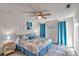 Bright bedroom featuring coastal-themed decor, a ceiling fan, and an inviting queen-sized bed at 2011 1St St, Indian Rocks Beach, FL 33785