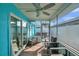 Relaxing screened-in porch with a ceiling fan, chairs, and backyard views with hot tub at 2011 1St St, Indian Rocks Beach, FL 33785