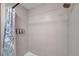 Modern tiled shower with sleek showerhead and blue-and-white patterned curtain at 2011 1St St, Indian Rocks Beach, FL 33785