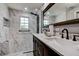 Elegant bathroom featuring marble countertops, a double vanity, and a glass-enclosed shower with modern fixtures at 2100 Mcmullen Rd, Largo, FL 33771