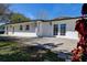Exterior of a white house featuring French doors, lawn, and mature landscaping at 2100 Mcmullen Rd, Largo, FL 33771