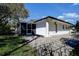 Exterior with a screened-in porch and a well-manicured lawn and landscaping at 2100 Mcmullen Rd, Largo, FL 33771