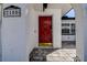 Elegant red front door with decorative details, set in a white stucco wall and brick paved entrance at 2100 Mcmullen Rd, Largo, FL 33771