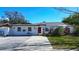 Charming white single-story home with red door, neat landscaping, and a spacious driveway at 2100 Mcmullen Rd, Largo, FL 33771