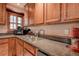 Traditional kitchen features a double sink, wood cabinets, and granite countertops, offering both style and functionality at 2100 Mcmullen Rd, Largo, FL 33771