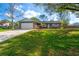 Attractive single-story home with a two-car garage, blue exterior, stone accents, and lush green lawn at 22700 Southshore Dr, Land O Lakes, FL 34639