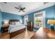 Blue bedroom featuring hardwood floors, white trim, wood furnishings and natural light from two windows at 2412 W Sunset Dr, Tampa, FL 33629