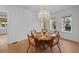 Dining area with seating for six, wood floors and a modern chandelier at 2412 W Sunset Dr, Tampa, FL 33629