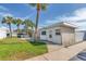 Home exterior with a well-manicured lawn and towering palm trees along the sidewalk at 250 Rosery Nw Rd # 329, Largo, FL 33770