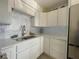 Modern kitchen with white cabinets, stainless steel sink, and decorative backsplash tiles at 250 Rosery Nw Rd # 329, Largo, FL 33770