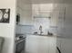 Updated kitchen with white cabinetry, stainless steel appliances, and a stylish tile backsplash at 250 Rosery Nw Rd # 329, Largo, FL 33770