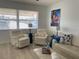 Inviting living room with white leather seating, light wood floors, and a large sunny window at 250 Rosery Nw Rd # 329, Largo, FL 33770