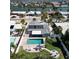 Aerial view of home with private pool, fenced yard, solar panels and waterfront views at 2504 Bayshore Dr, Belleair Beach, FL 33786