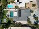 High aerial view of a home featuring solar panels, swimming pool, and tropical landscaping at 2504 Bayshore Dr, Belleair Beach, FL 33786