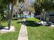 Scenic backyard walkway leading to waterfront views, framed by mature trees and lush greenery at 2504 Bayshore Dr, Belleair Beach, FL 33786