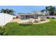 Expansive backyard featuring a pool, umbrellas, and outdoor seating, ideal for entertaining at 2504 Bayshore Dr, Belleair Beach, FL 33786
