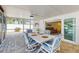 Relaxing screened porch with a stylish table set for outdoor dining overlooking the pool area at 2504 Bayshore Dr, Belleair Beach, FL 33786