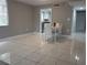 Bright dining area with tile flooring, view into kitchen, and a modern white dining set at 2630 Pearce Dr # 103, Clearwater, FL 33764