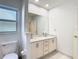 This bright bathroom features double sinks with white countertop and a private toilet room at 2725 Onizuka Ct, Palm Harbor, FL 34683
