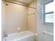 Neutral bathroom with a bathtub, shower and window at 2725 Onizuka Ct, Palm Harbor, FL 34683