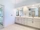 Bright bathroom featuring double vanities with ample counter space and large mirrors at 2725 Onizuka Ct, Palm Harbor, FL 34683