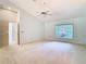 Spacious bedroom with a ceiling fan, neutral paint, carpet flooring, and a large window overlooking the yard at 2725 Onizuka Ct, Palm Harbor, FL 34683