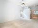 Bright bedroom with white walls, ceiling fan, neutral carpet, and doorway to bathroom at 2725 Onizuka Ct, Palm Harbor, FL 34683