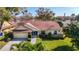 Charming single-story home with well-manicured lawn, attached garage, and inviting entrance at 2725 Onizuka Ct, Palm Harbor, FL 34683