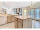 Open kitchen with tile floors, a central island, sink, and access to a bright living space and outdoor patio at 2725 Onizuka Ct, Palm Harbor, FL 34683