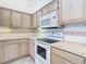 Close-up of a kitchen with an oven, microwave, and light wood cabinets, creating a functional cooking space at 2725 Onizuka Ct, Palm Harbor, FL 34683