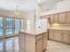 Bright kitchen with island, white appliances, tile floors, and access to outdoor spaces through glass doors at 2725 Onizuka Ct, Palm Harbor, FL 34683
