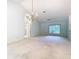 Bright living room with chandelier, ceiling fan, and window overlooking the garden at 2725 Onizuka Ct, Palm Harbor, FL 34683